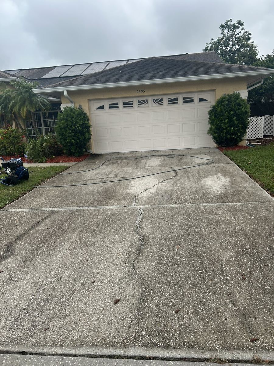 Concrete driveway stained and darkened before cleaning