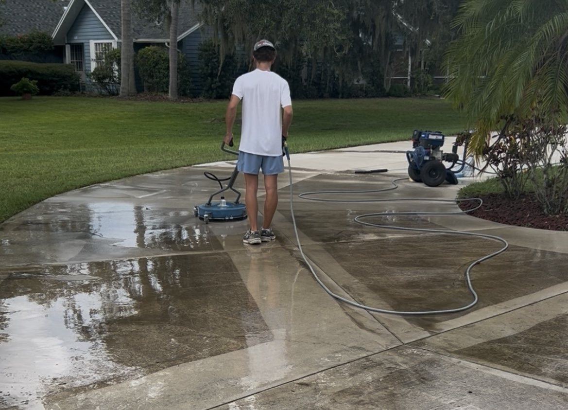 Jared running a rotary surface cleaner on a residential driveway