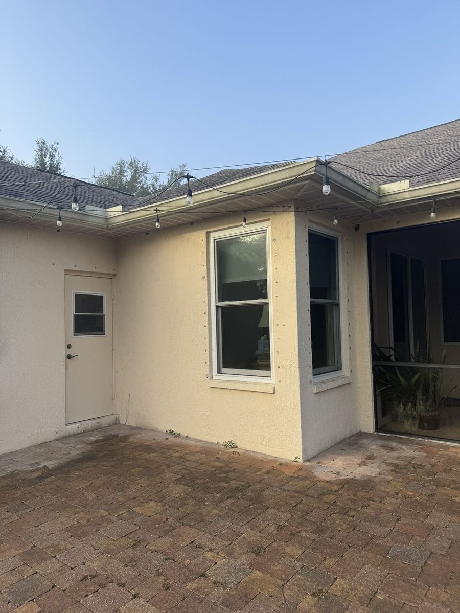 Paver patio and stucco wall before soft washing