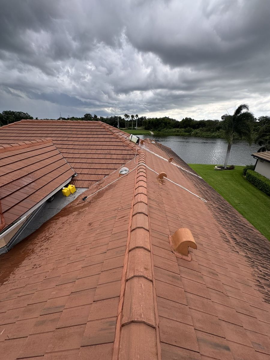 Tile roof during soft washing, low-pressure solution applied