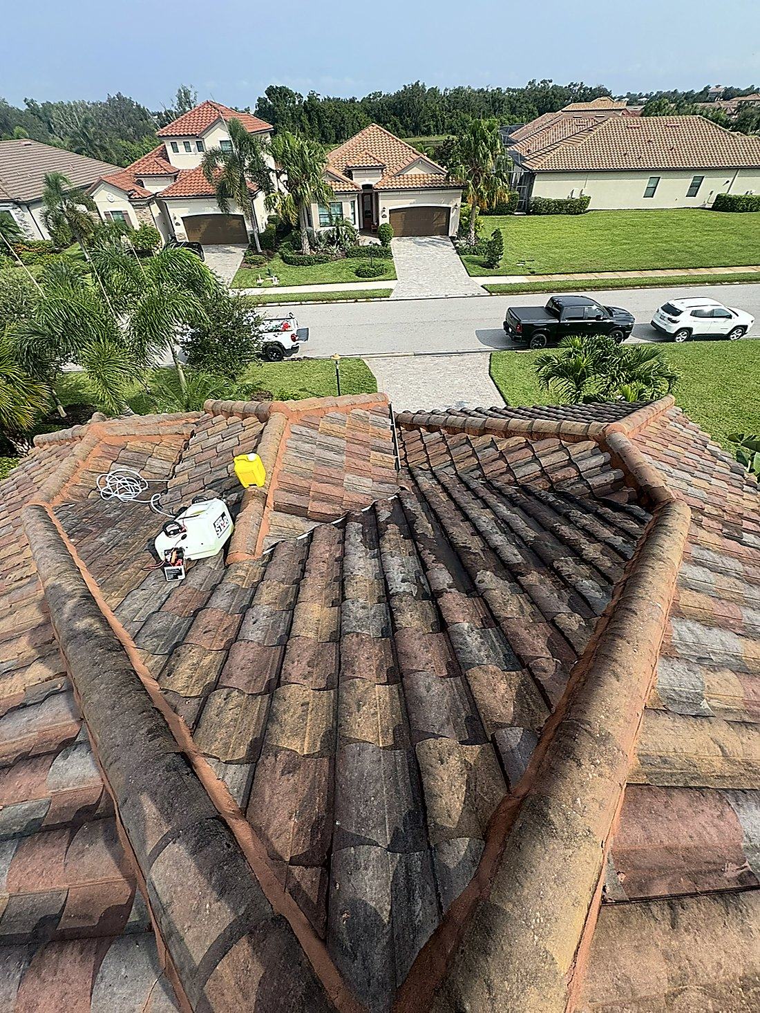 The same barrel tile roof before soft washing, covered in black algae streaks